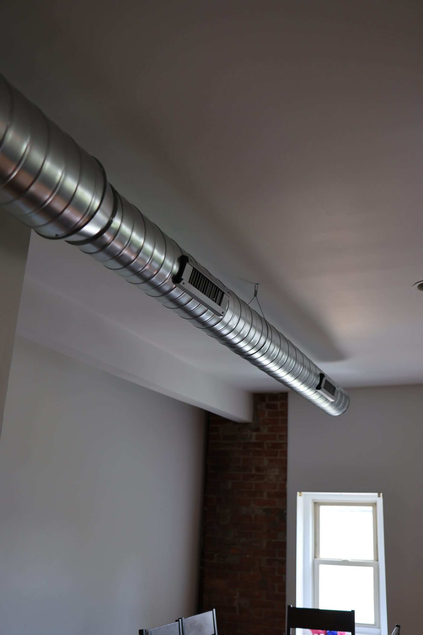 Spiral duct and supply registers crossing a finished room